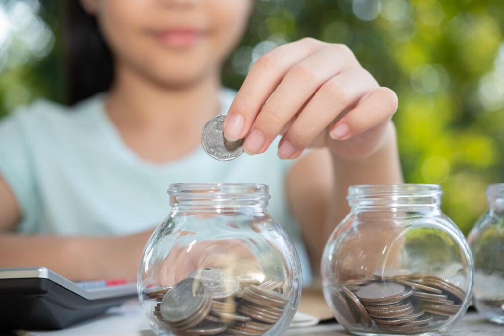 cute-asian-little-girl-playing-with-coins-making-stacks-money-kid-saving-money-into-piggy-bank-into-glass-jar-child-counting-his-saved-coins-children-learning-about-future-concept-1024x683